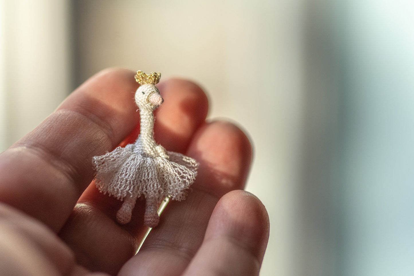 Handmade miniature swan with crown on neutral background