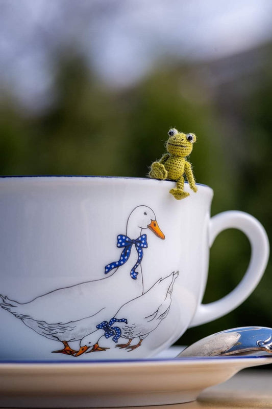 Miniature green amigurumi frog with big eyes