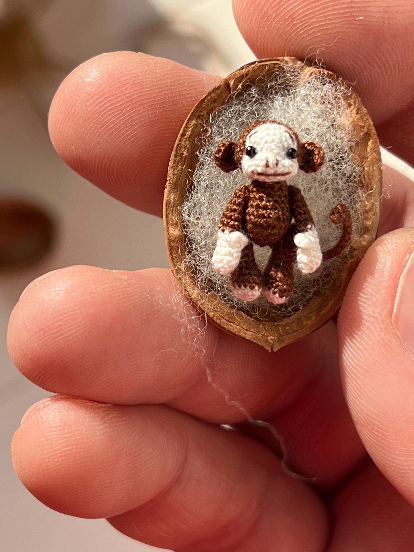 Pocket-sized monkey toy with smiling face and stitched details