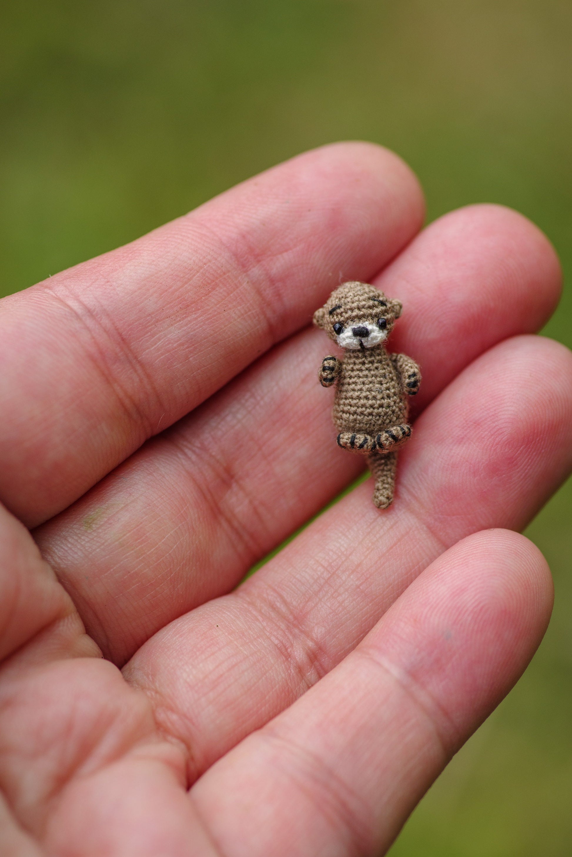 Handmade otter figure with bendable tail resting in a playful tabletop river
