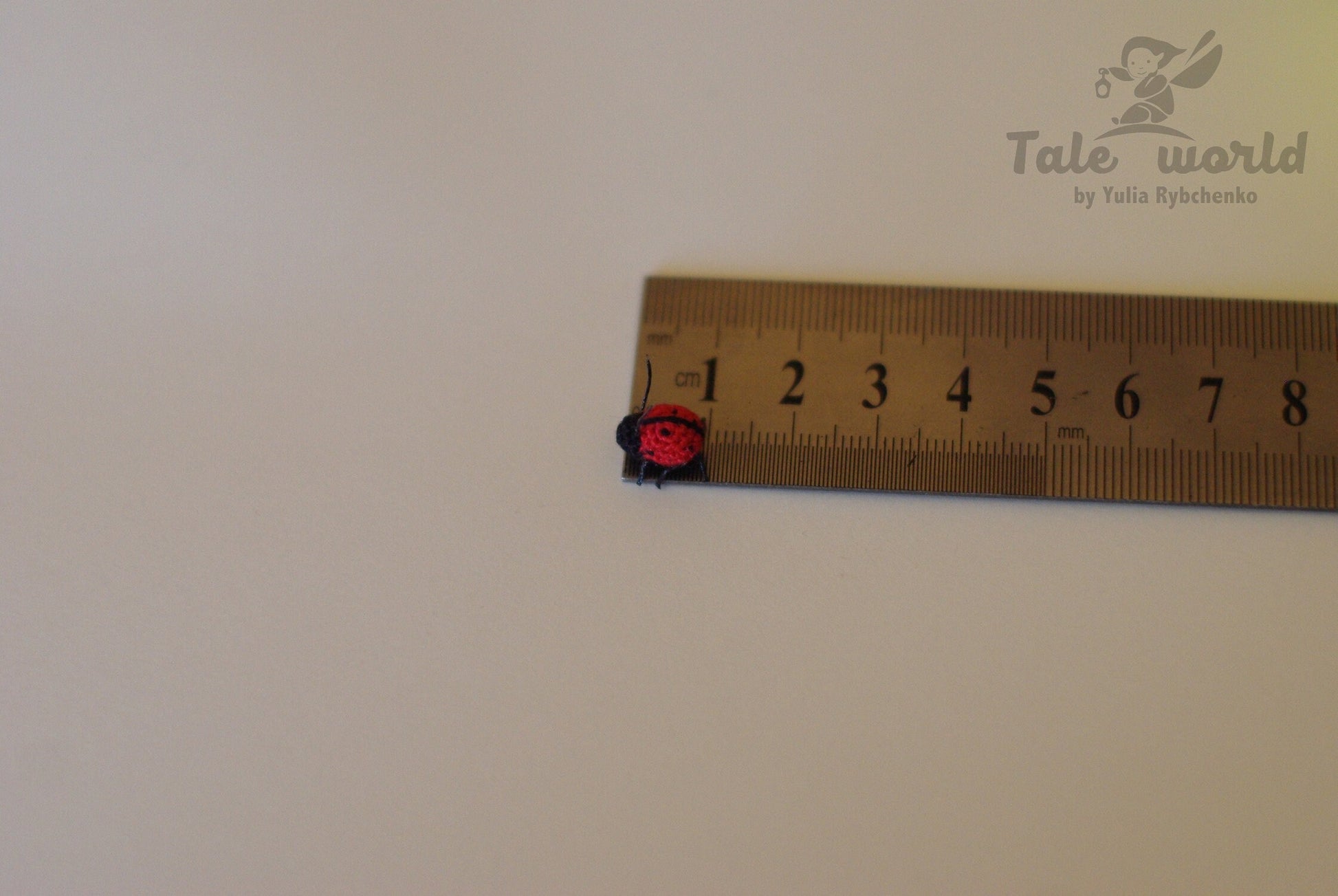 Small toy figure on a ruler for scale measurement against a plain background