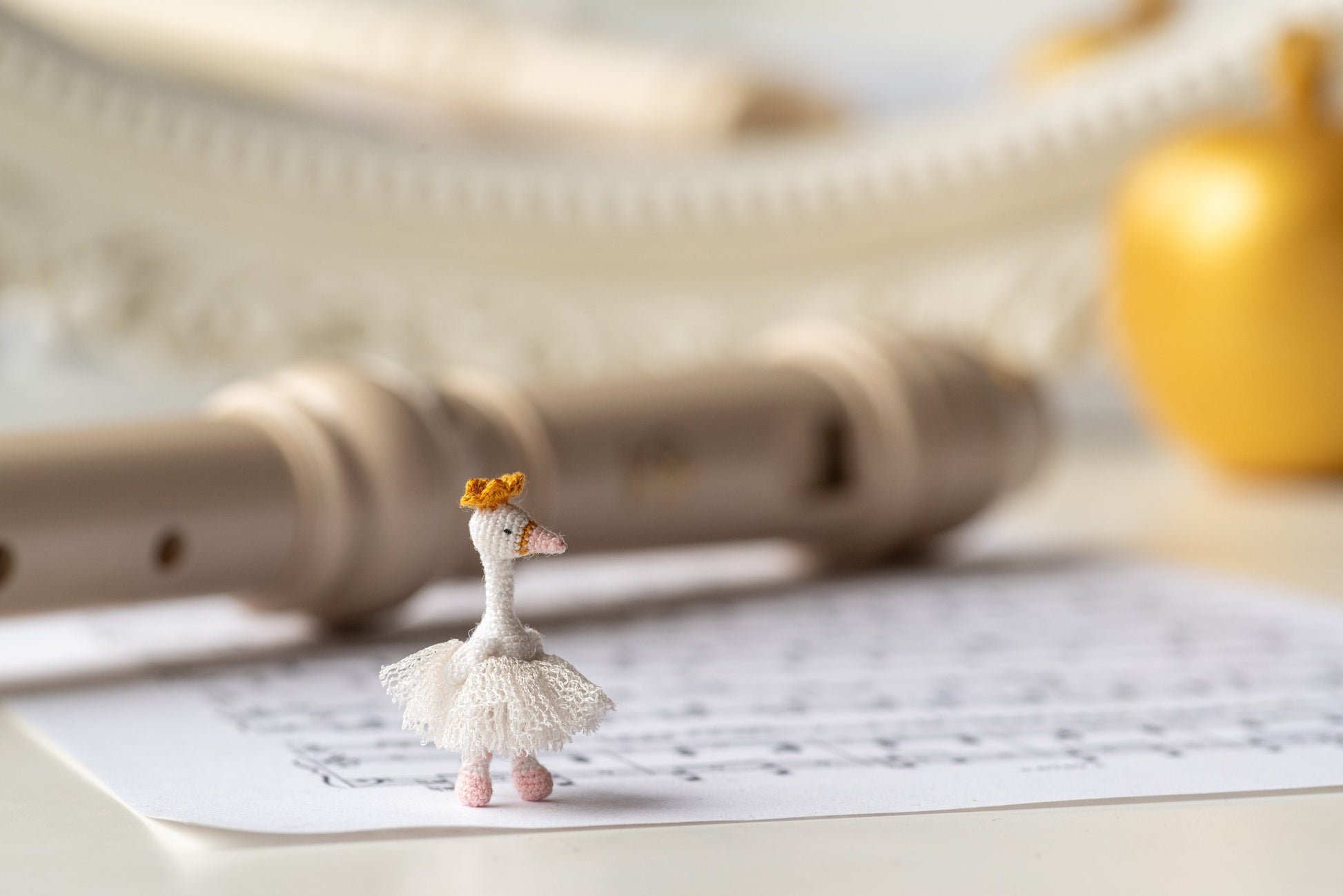 Tiny crochet swan figurine in hand for scale