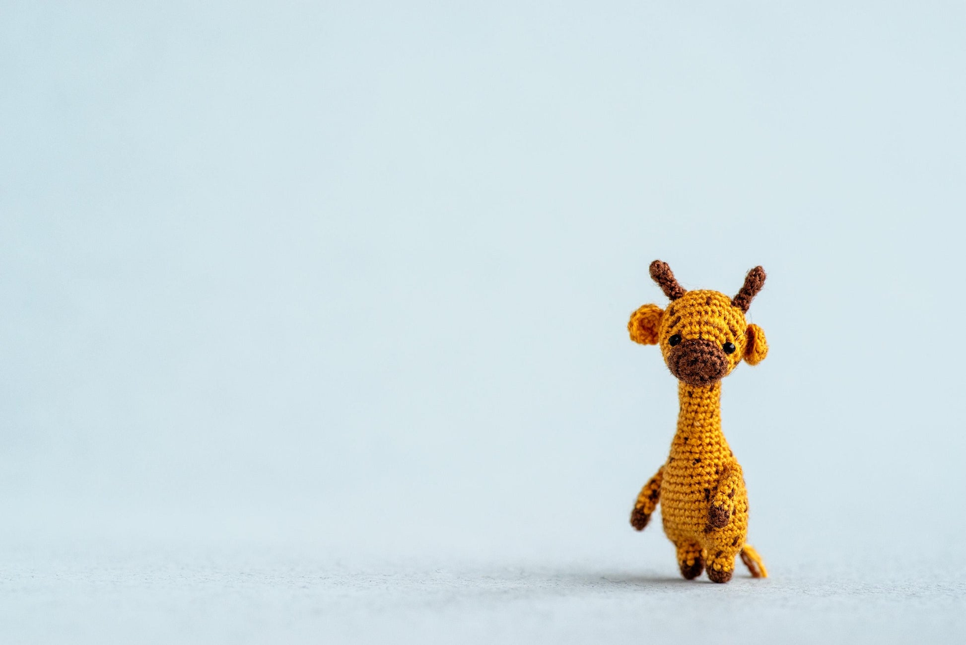 Miniature amigurumi giraffe with long neck and soft spots