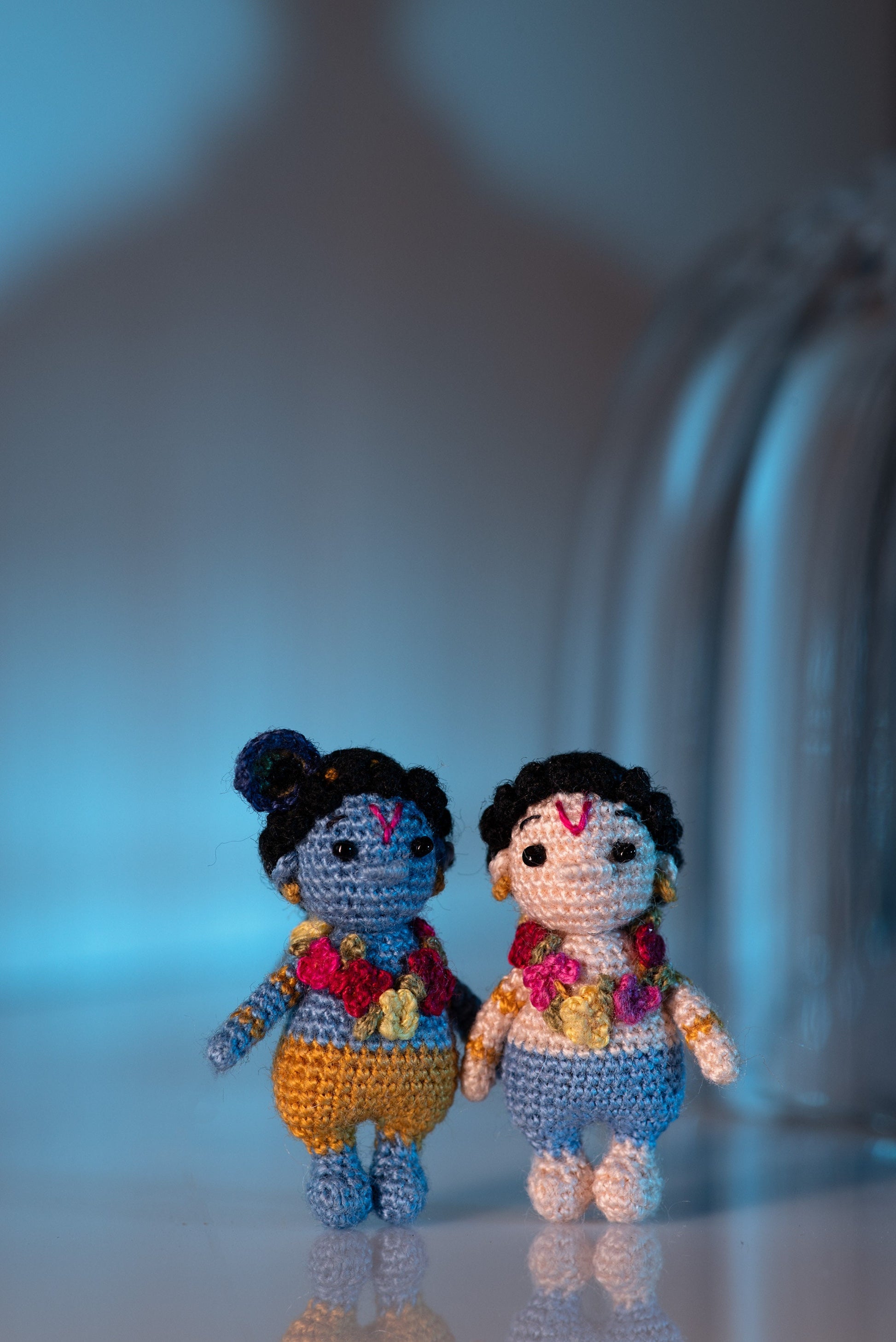 Handmade Hindu deity doll with embroidered face and joyful expression.