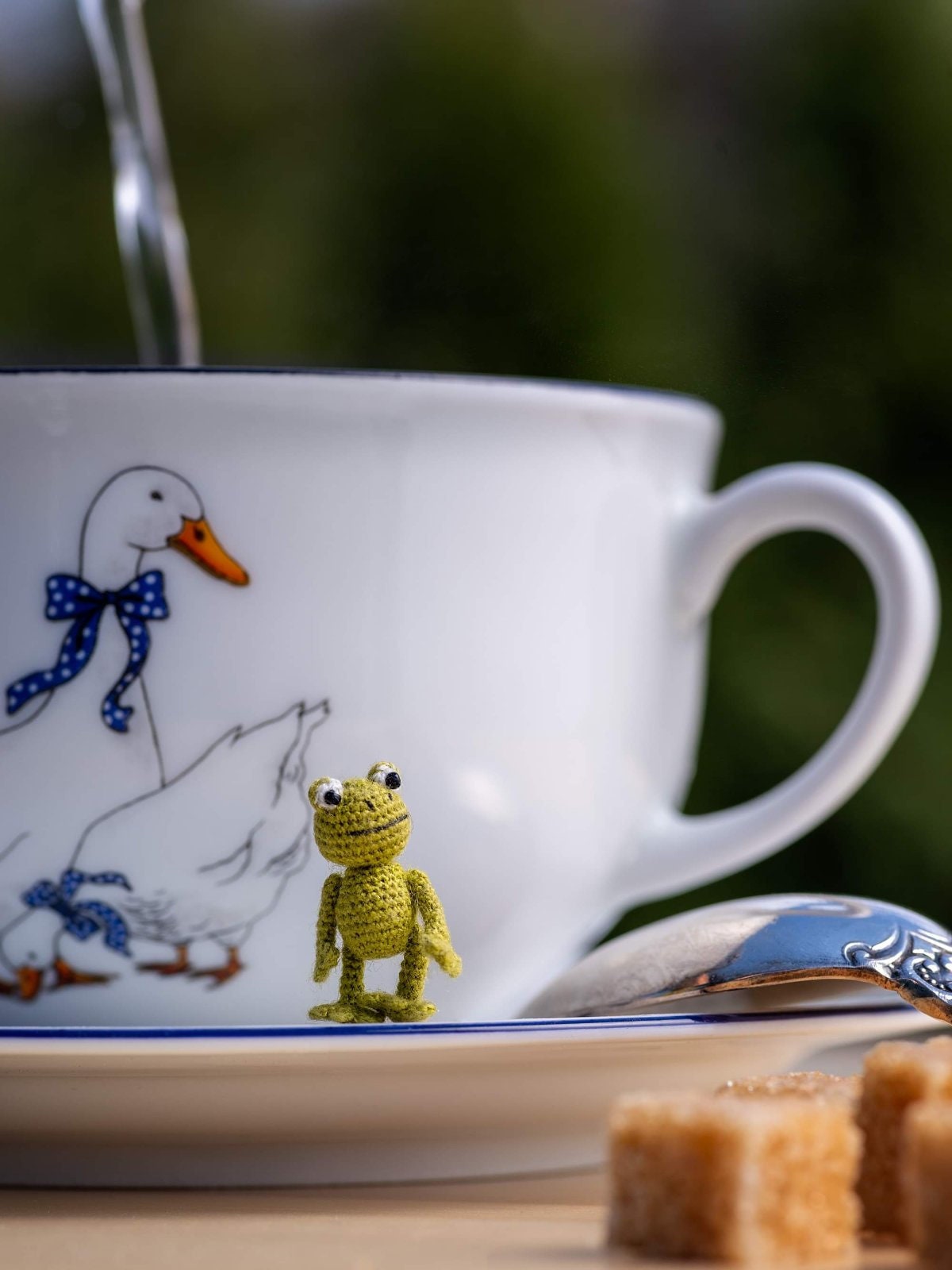 Whimsical tiny frog enjoying tea time