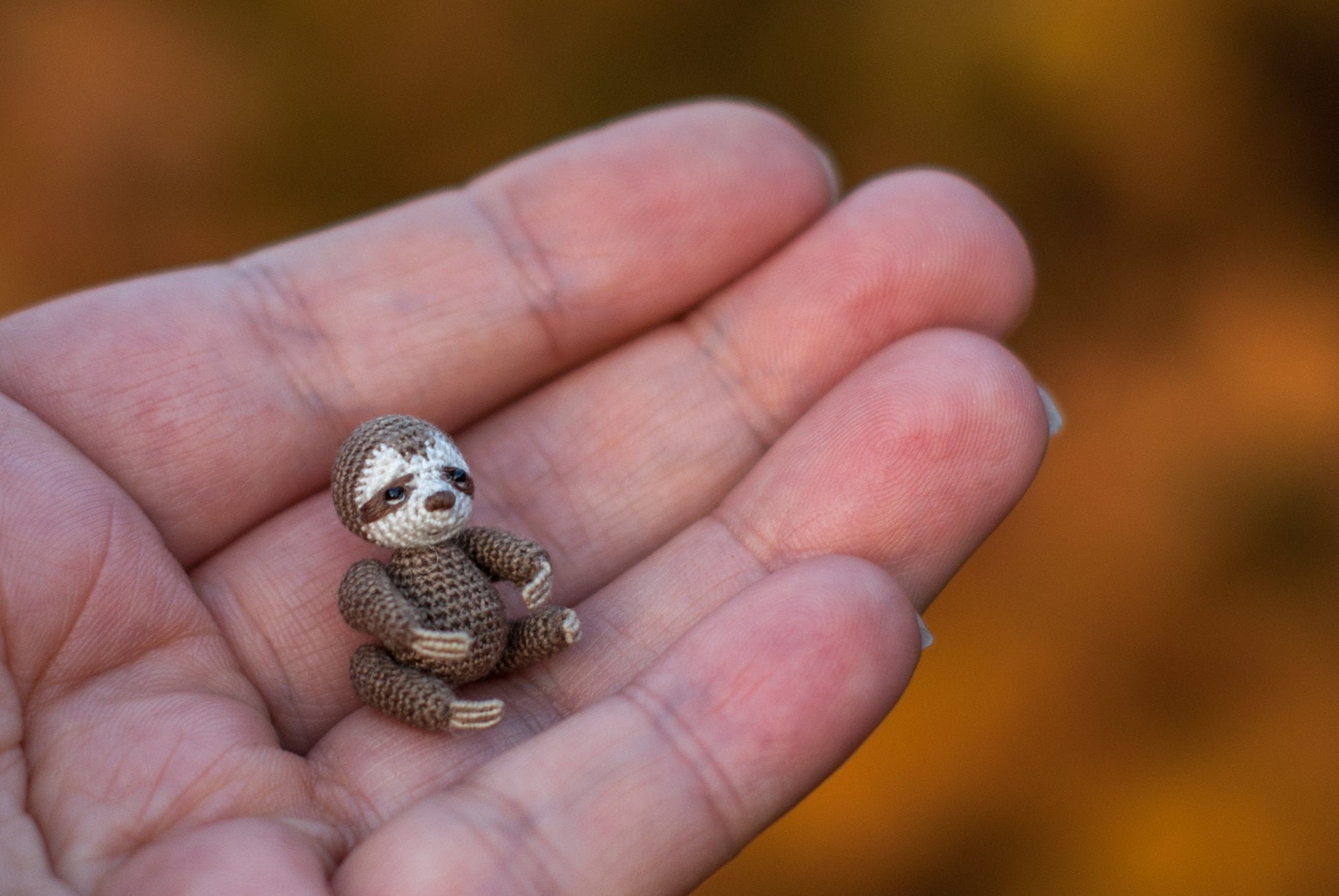 Close-up of crochet sloth on a branch — peaceful and detailed