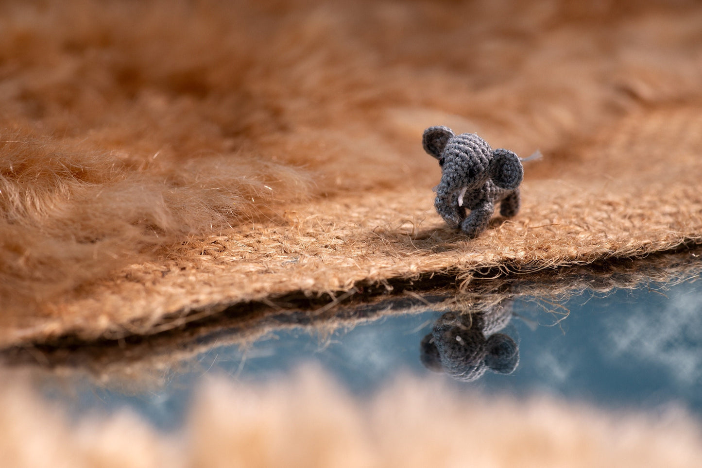 Miniature amigurumi elephant walking toward a river