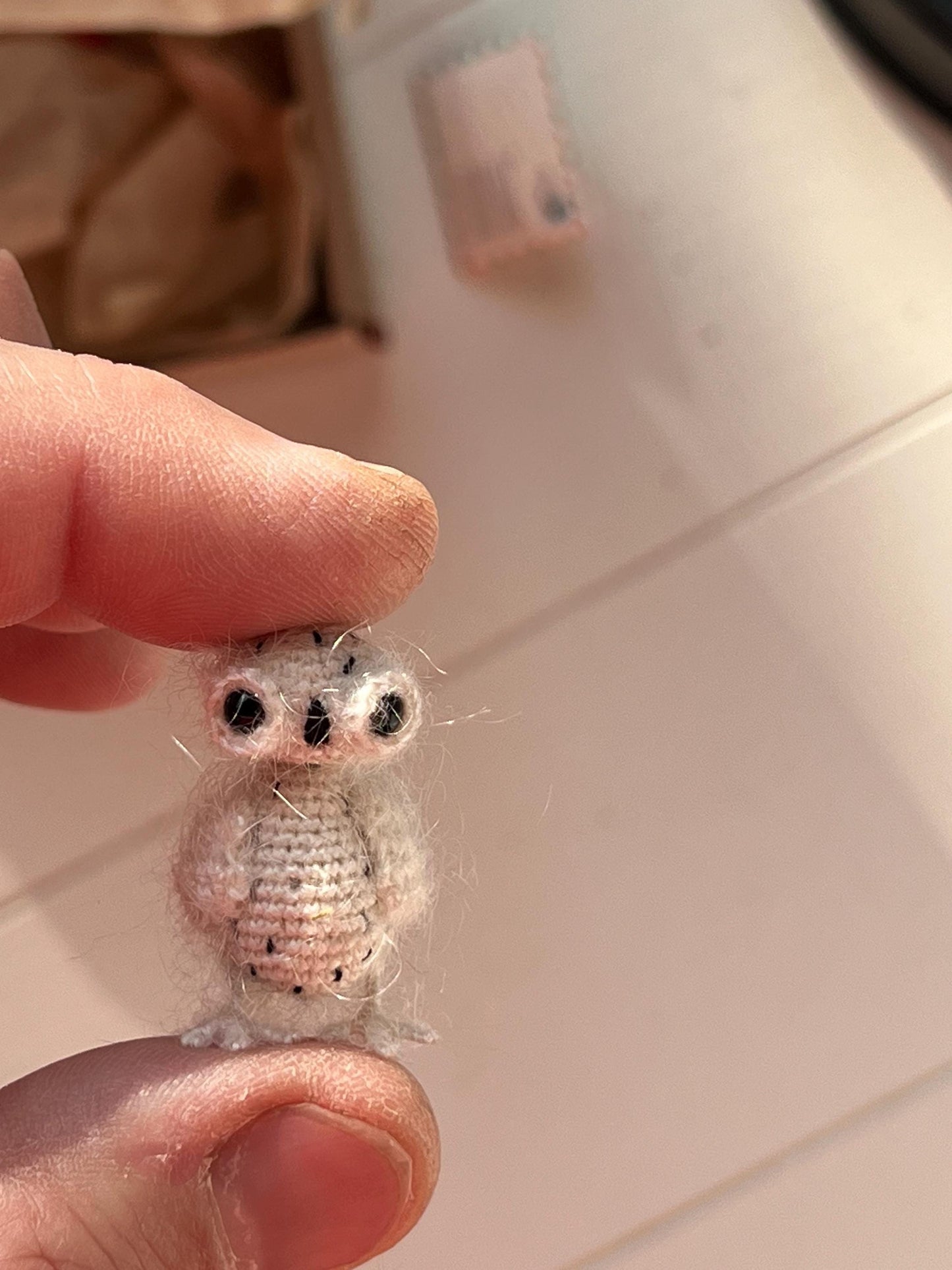 Small crochet bird with black eyes and feather texture