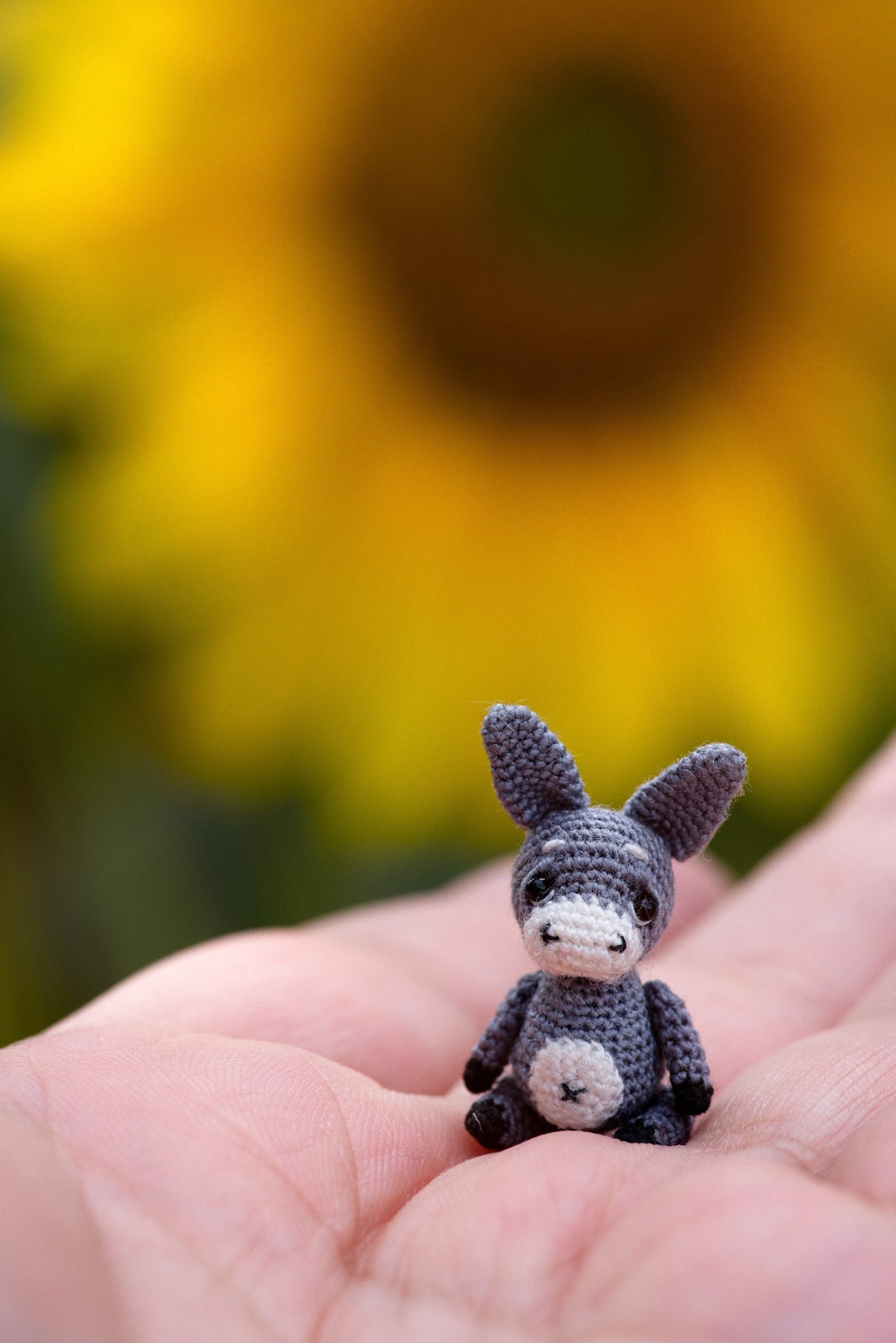 Tiny crochet donkey in hand – collectible soft sculpture from TaleWorld