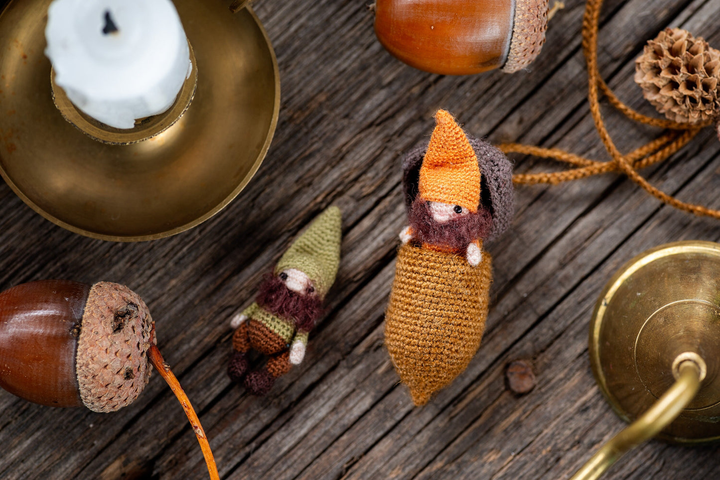 Handmade orange-hatted gnome peeking out of his acorn pod with a wooly beard