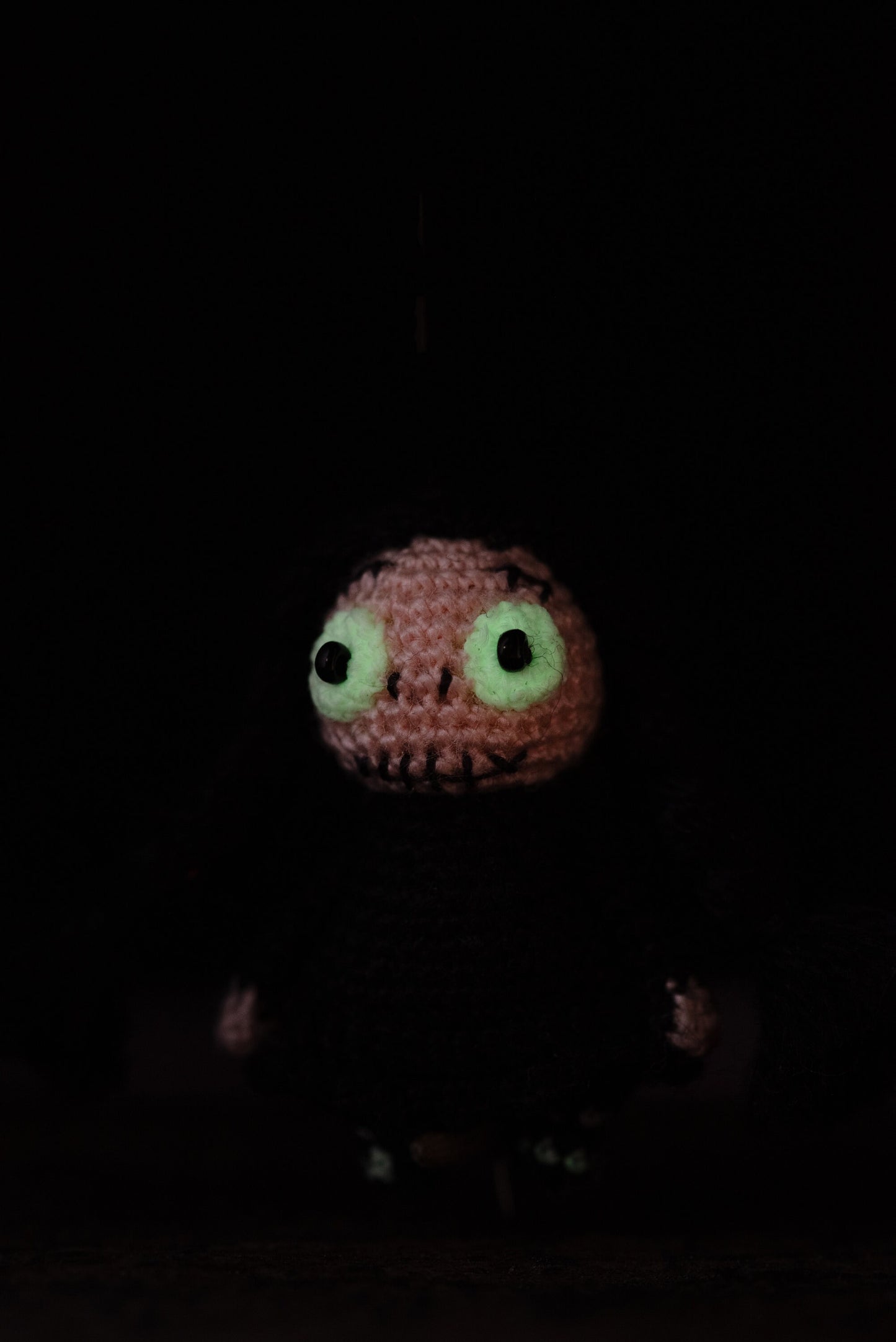 Miniature crochet gothic doll with black braids and luminous glow-in-the-dark eyes