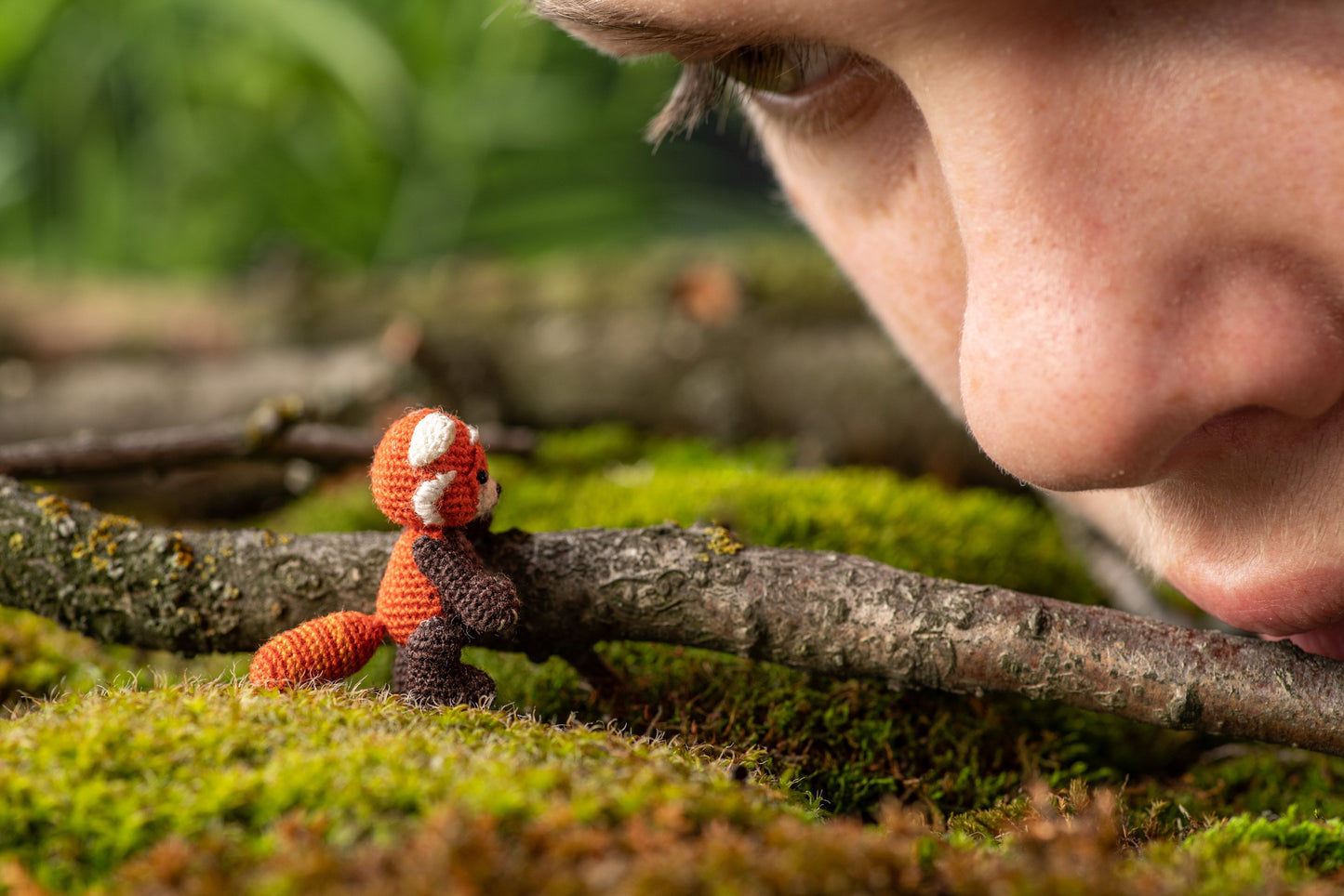 Miniature amigurumi red panda with black body and orange head