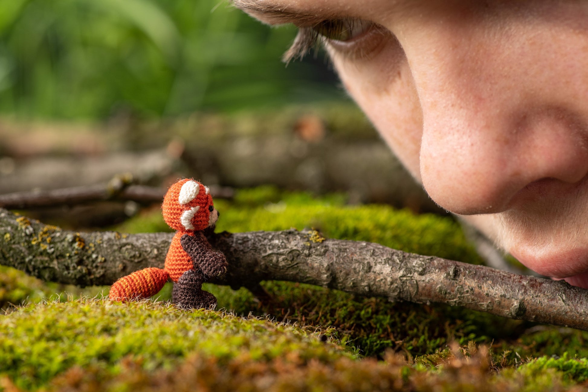 Miniature amigurumi red panda with black body and orange head