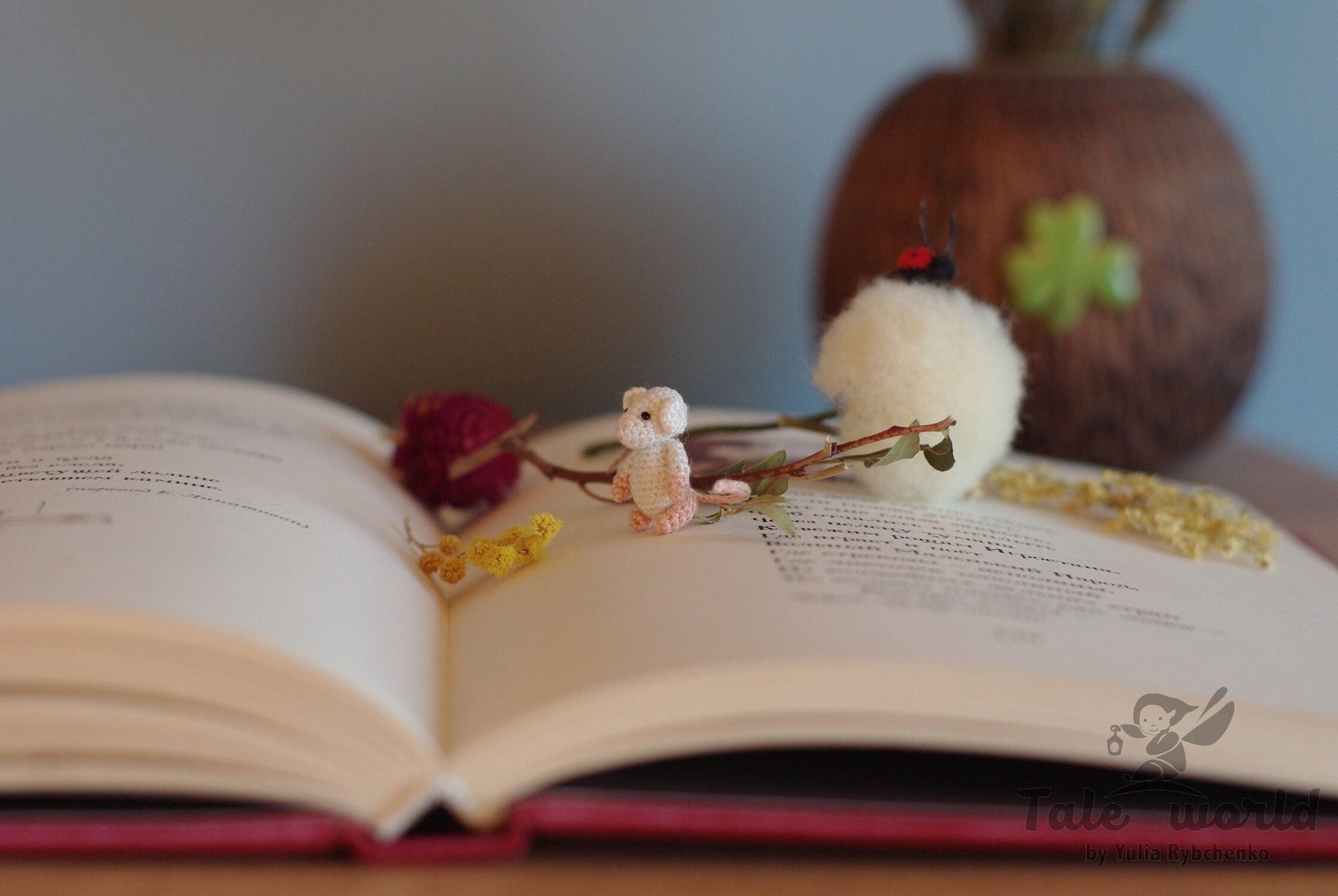 Small handmade rat with long tail on pages