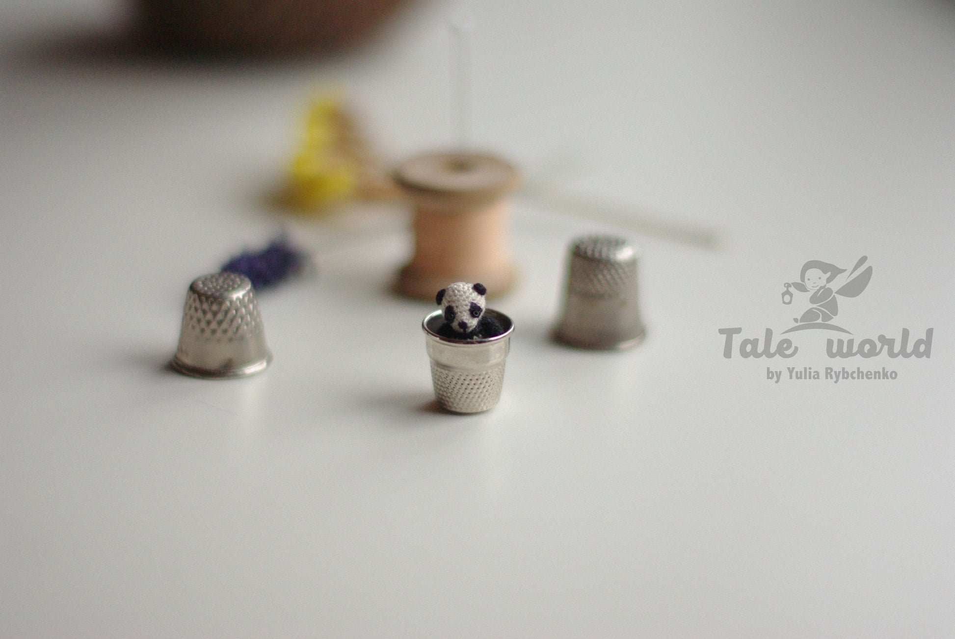 Panda figure photographed in hand, showing delicate scale and detail.