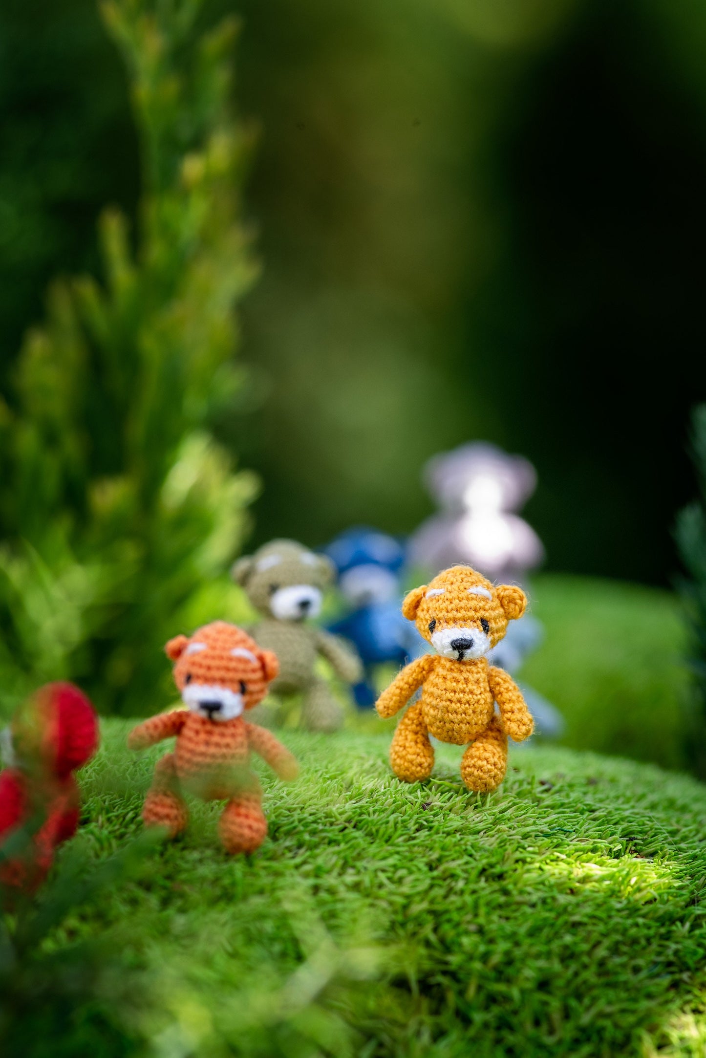 Tiny plush animals posed on green landscape