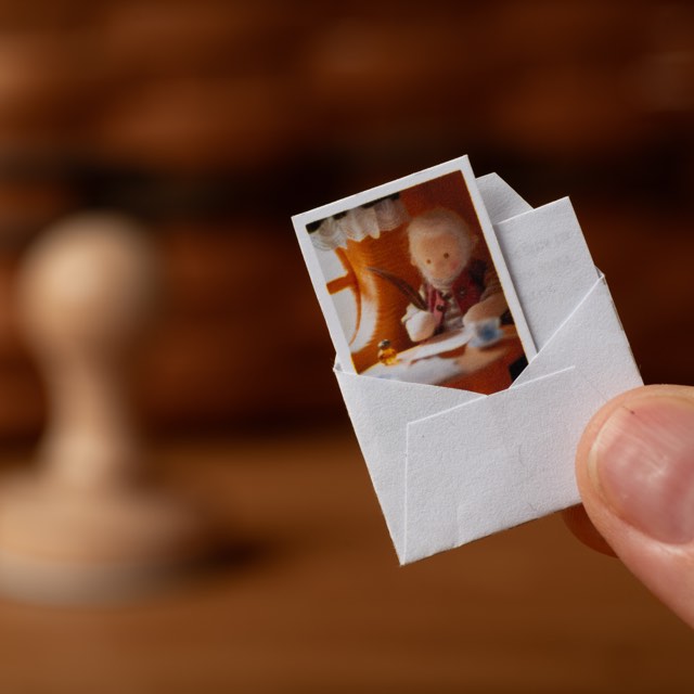 A miniature postcard of Vasyl at his desk, standing on the table of the post office.